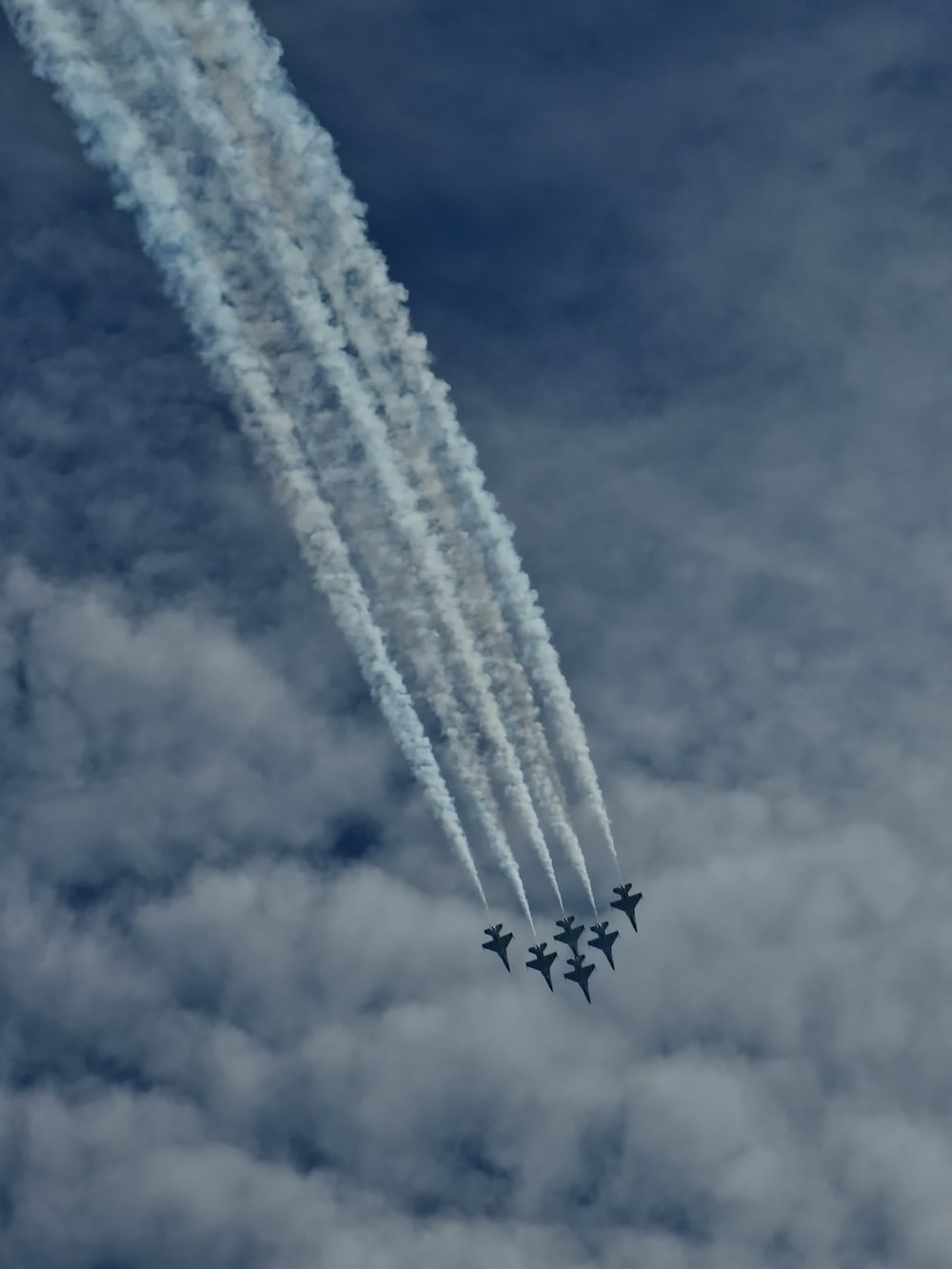 a group of jets flying through a cloudy sky