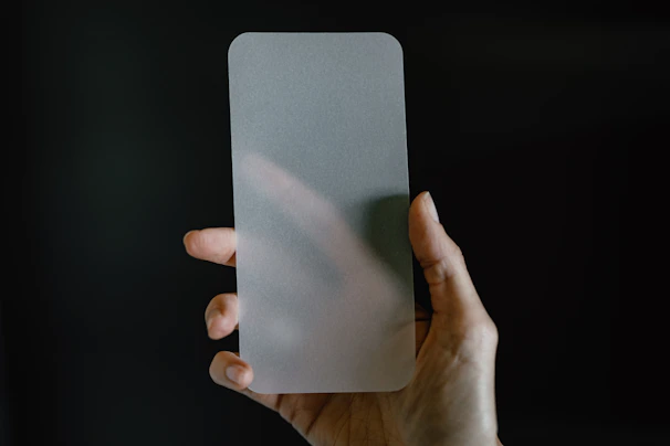 Close-up of a tempered glass screen protector being applied smoothly on a smartphone