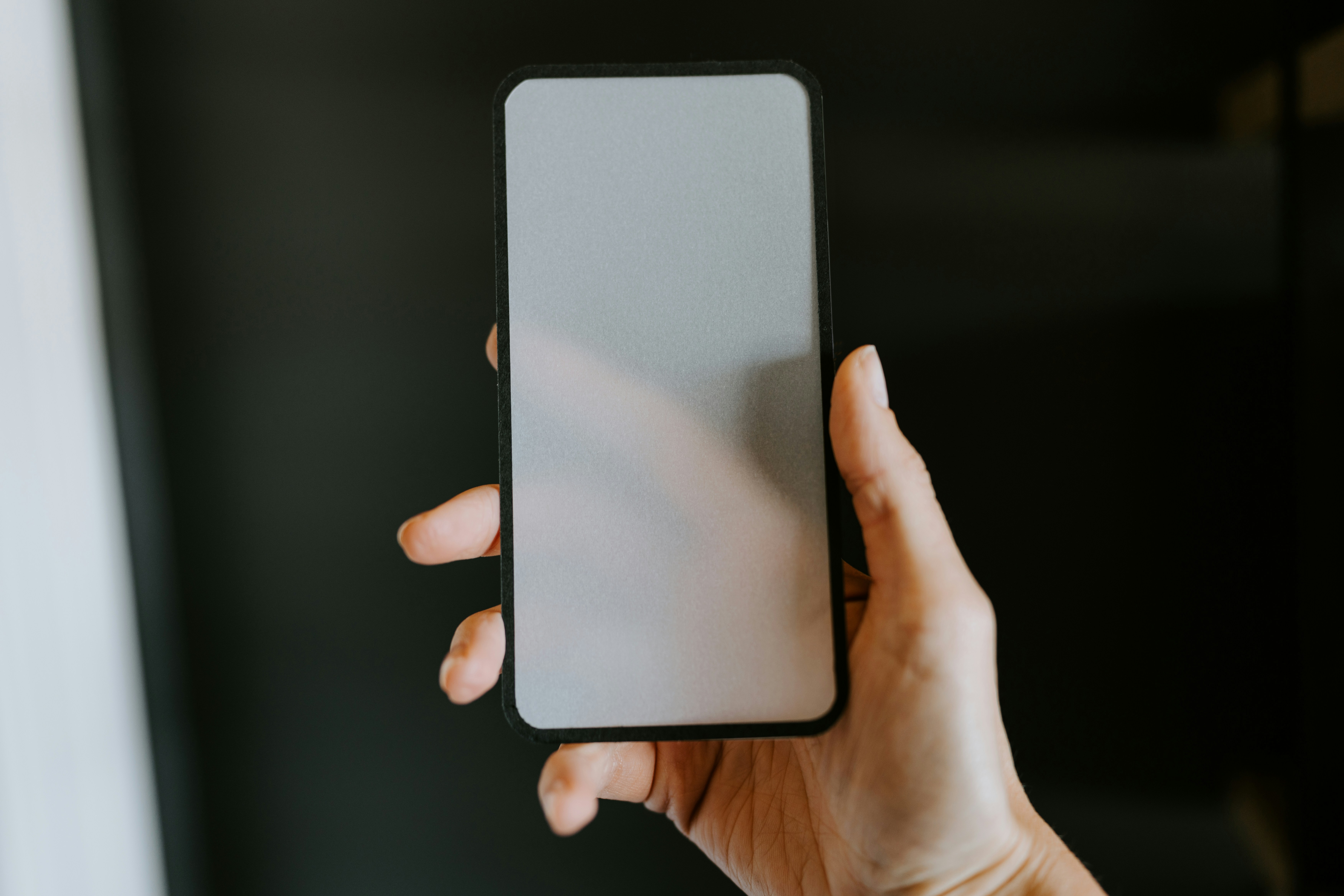 a person holding a cell phone in their hand, 