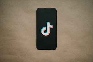 A friendly person using a smartphone to create a TikTok ad.