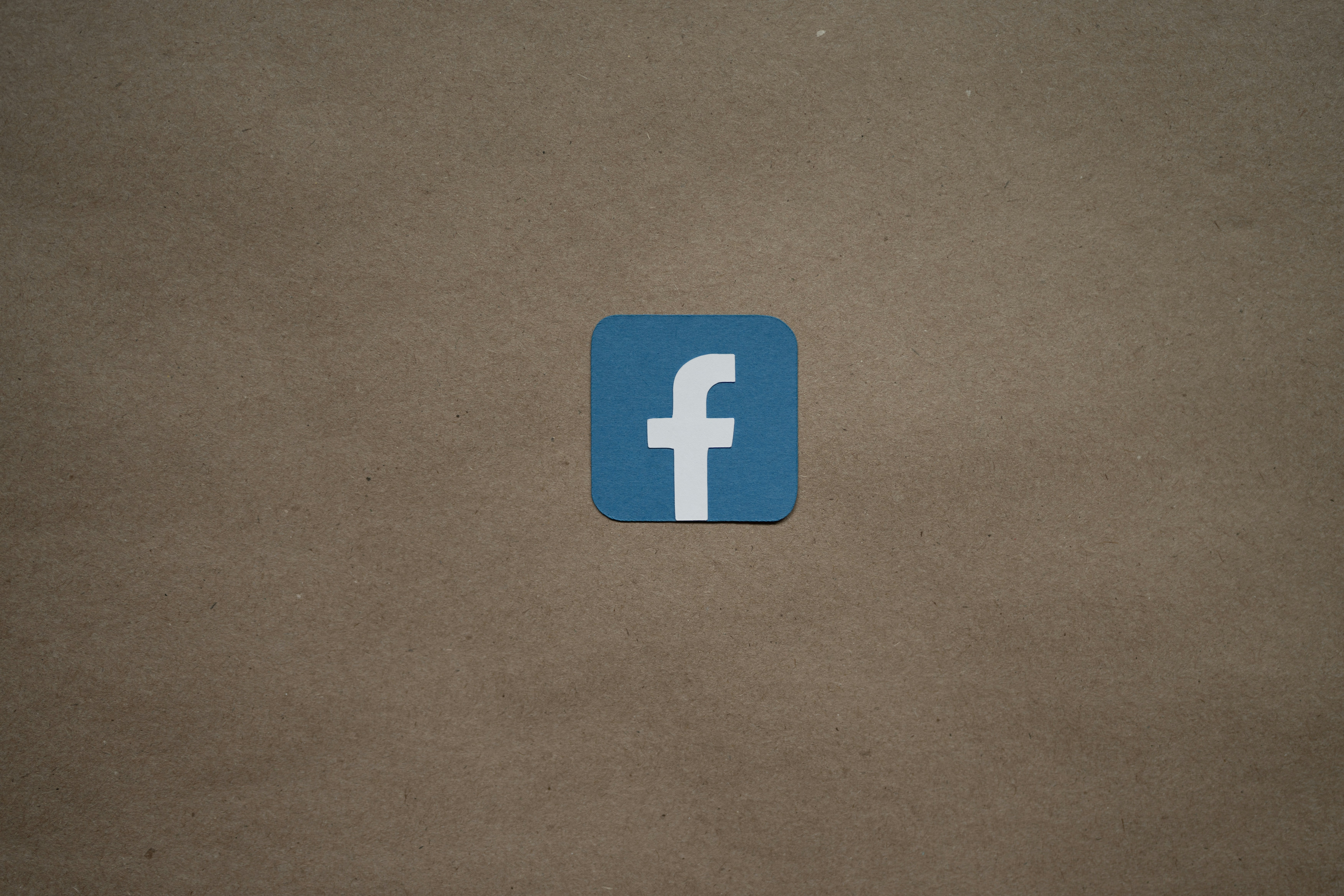 a blue facebook logo on a brown background