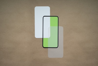 Three overlapping rectangular shapes are placed on a neutral brown background. The top shape is a plain white rectangle, the center rectangle has a black border with a split design of white and green, and the bottom one is transparent with a slight gray tint.