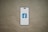 A smartphone is depicted with a white screen displaying a blue logo with the letter 'f', set against a plain brown background.