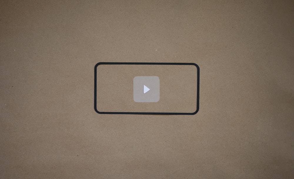 Un botón de reproducción de vídeo en un trozo de papel marrón