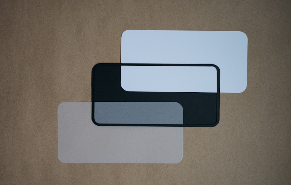 a couple of white and black coasters on a brown surface