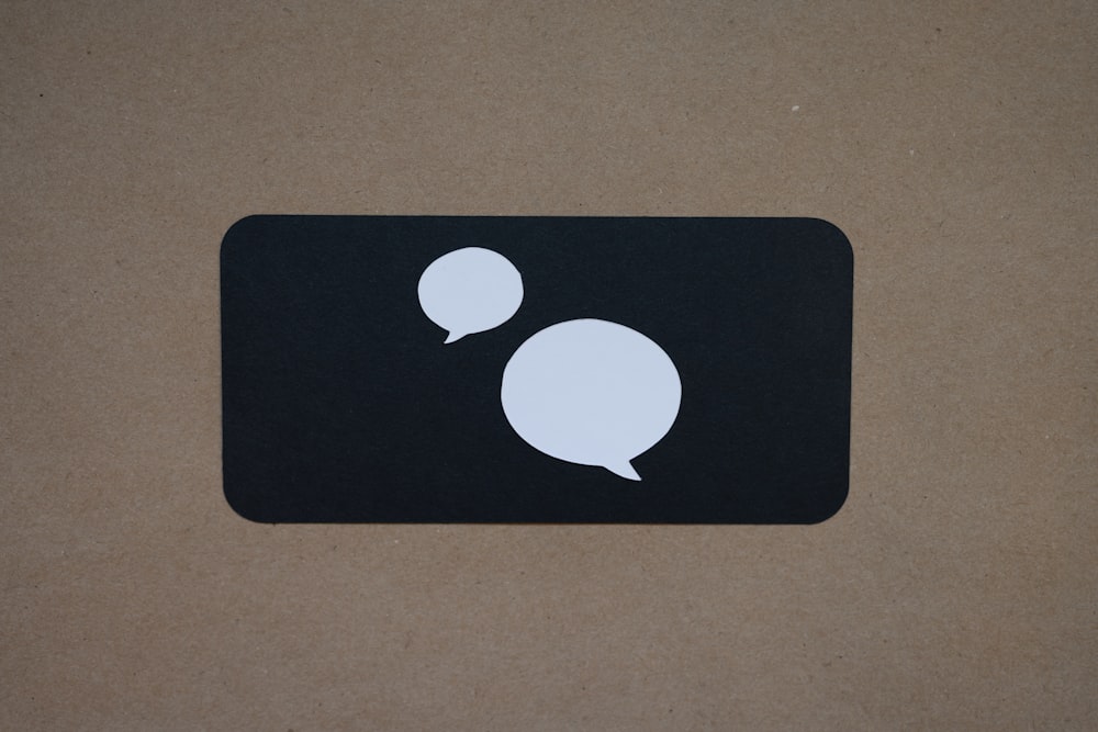 a black square with a white speech bubble on it