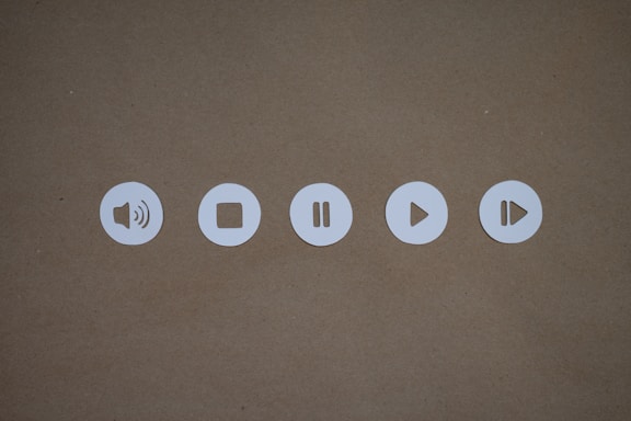 a set of four white buttons on a brown surface