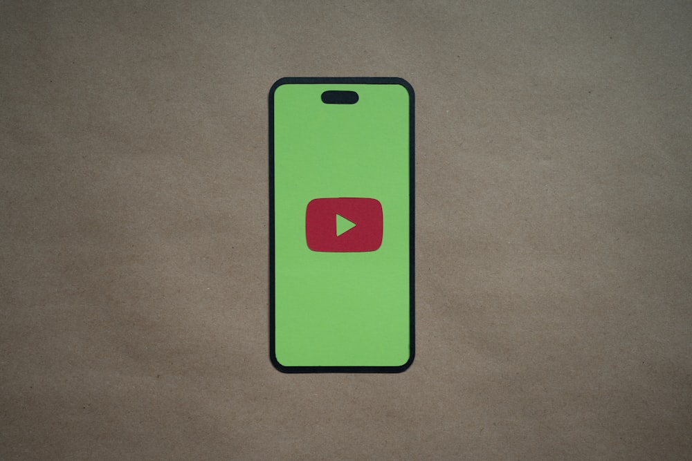 a green phone with a red play button on it
