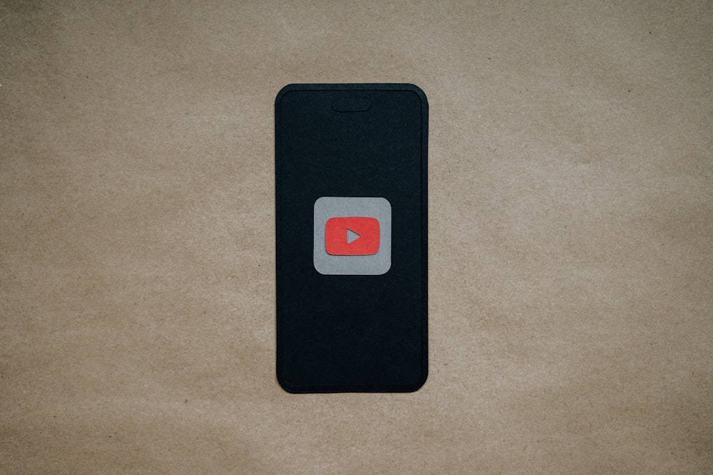 a black cell phone with a red youtube logo on it