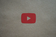 a red play button sitting on top of a piece of paper
