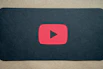 A YouTube play button icon on a red background