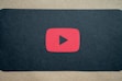 A dynamic YouTube play button icon glowing against a dark background