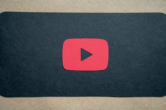 Screenshot of a video gallery page with dark grey background and red highlights featuring YouTube video thumbnails