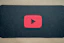 A YouTube play button icon on a red background