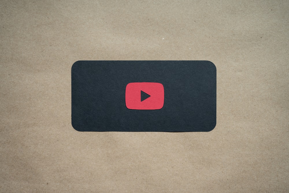 a black square with a red youtube logo on it