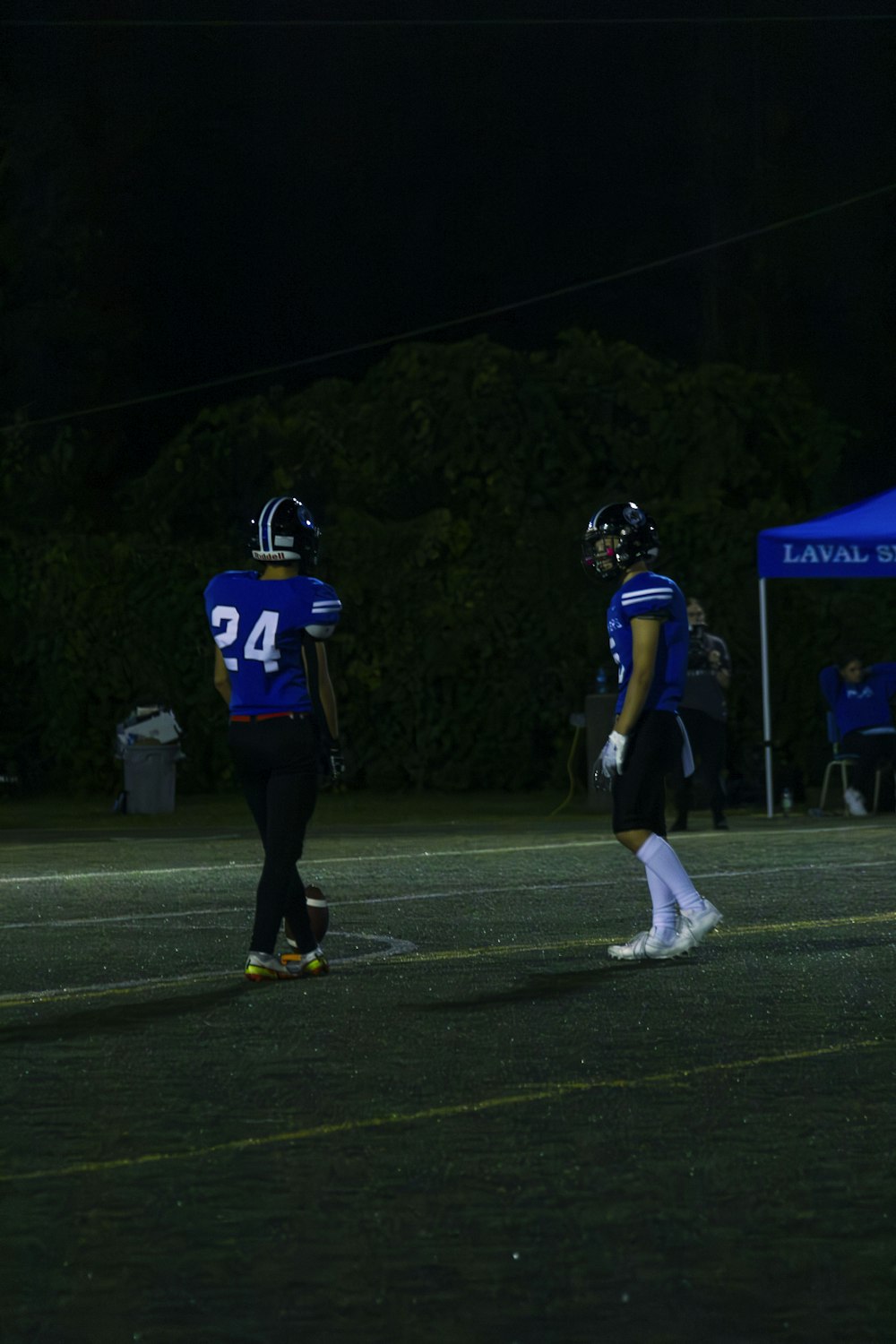 a couple of football players standing on top of a field