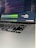Close-up of hands coding on a laptop with AI-related graphics on screen.
