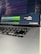 Close-up of hands coding on a laptop with AI-related graphics on screen.