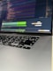 A close-up of a person typing on a laptop with cybersecurity code on the screen.
