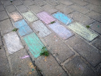 Children drawing with chalk on a sidewalk, showcasing creativity.