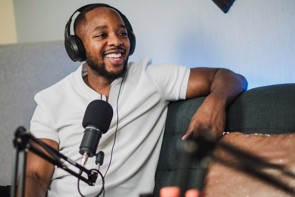 a man wearing headphones sitting in front of a microphone