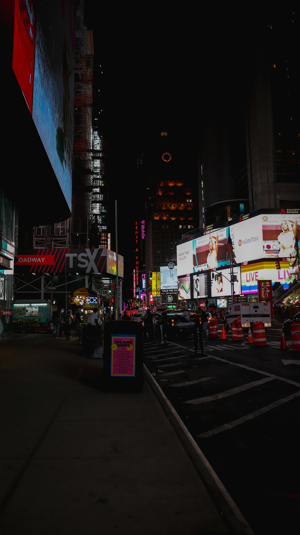 a city street at night with a lot of neon signs