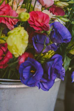 A vibrant hand bucket flower arrangement with fresh colorful blooms.