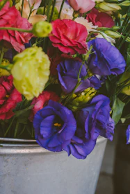 A vibrant hand bucket flower arrangement with fresh colorful blooms.
