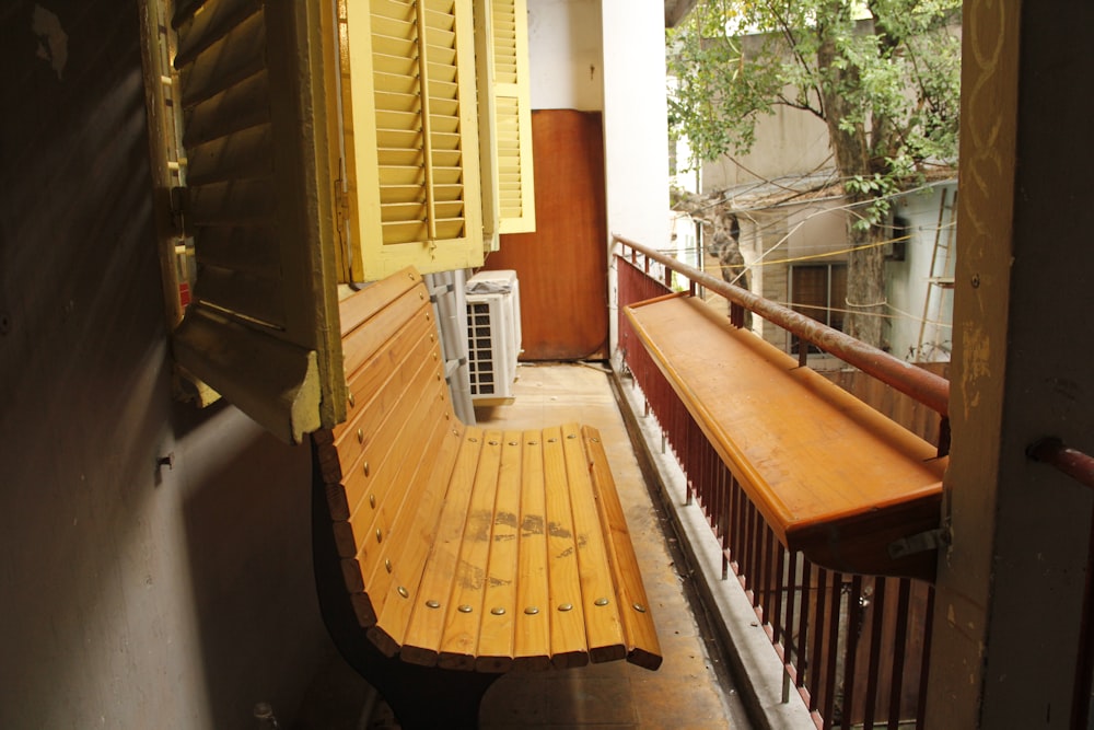 a wooden bench sitting on the side of a building