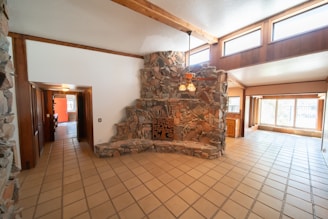 Wide shot of a living room with freshly installed stone tile flooring reflecting natural light.