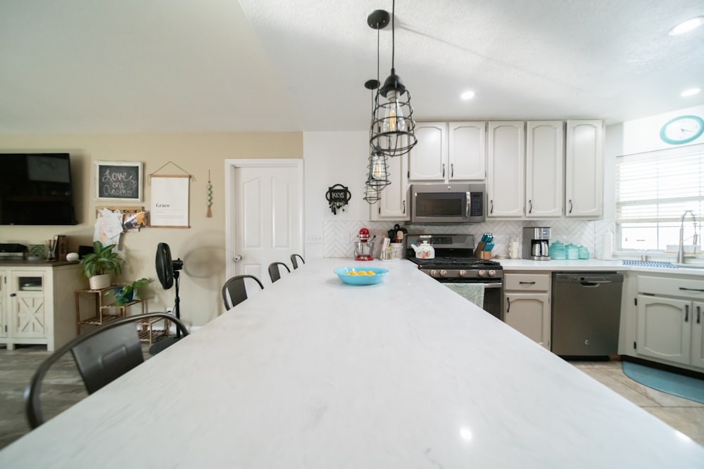 a kitchen with a white counter top next to a stove top oven