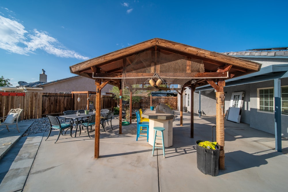 a covered patio with a table and chairs