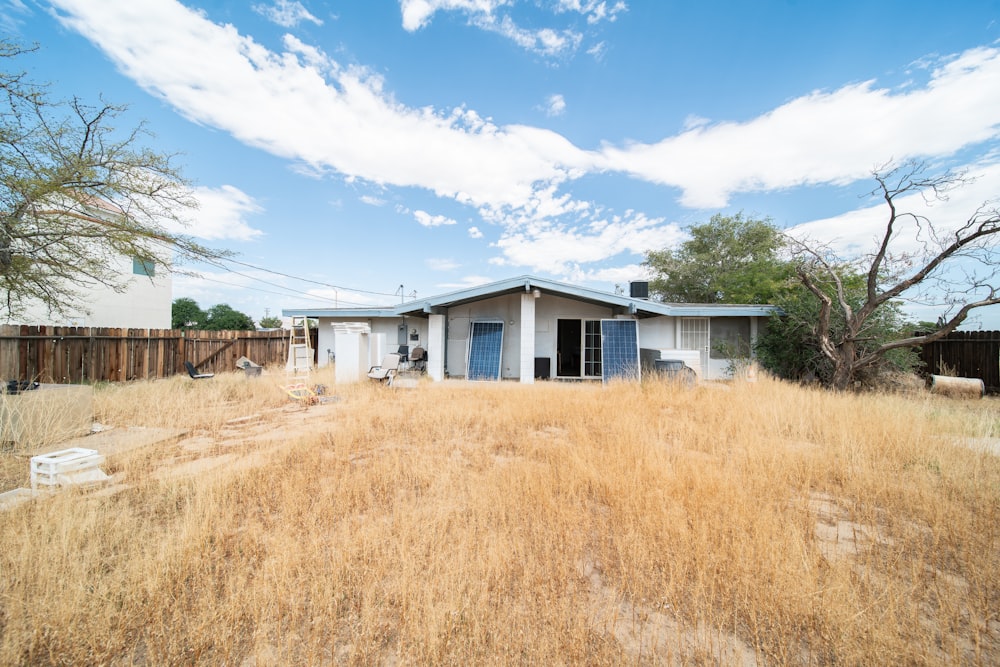 a house in the middle of a dry grass field