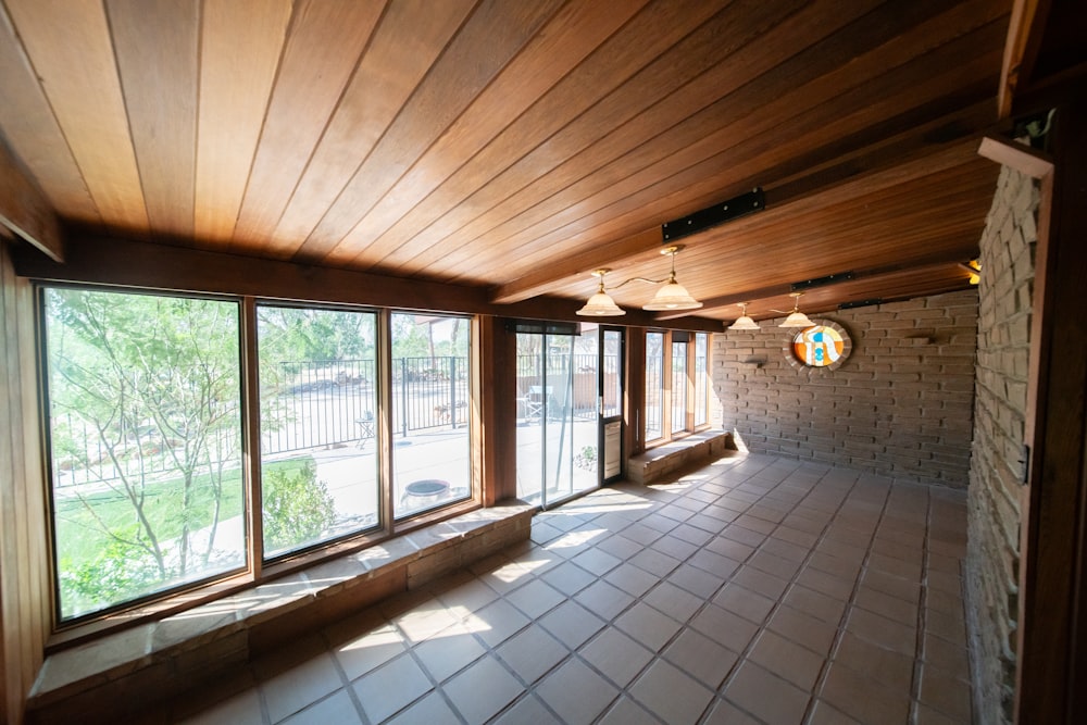 Une chambre avec beaucoup de fenêtres et un sol carrelé