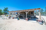 Small casita with a cozy porch, surrounded by native Texas plants under a bright blue sky