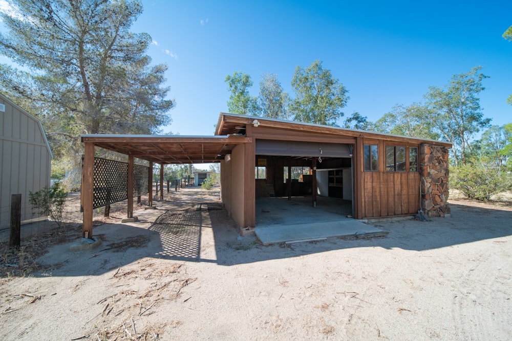 a building with a covered entrance in the middle of a dirt field