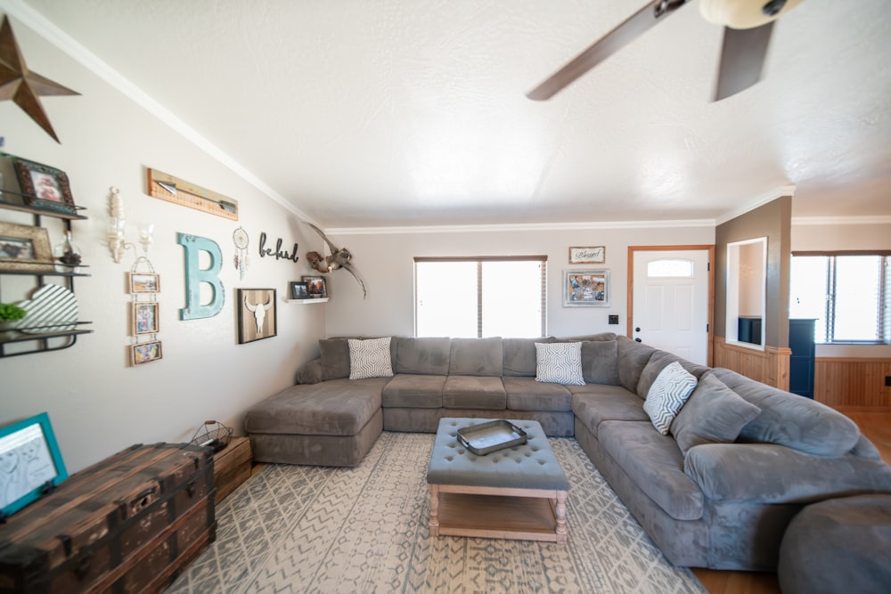 a living room filled with furniture and a ceiling fan