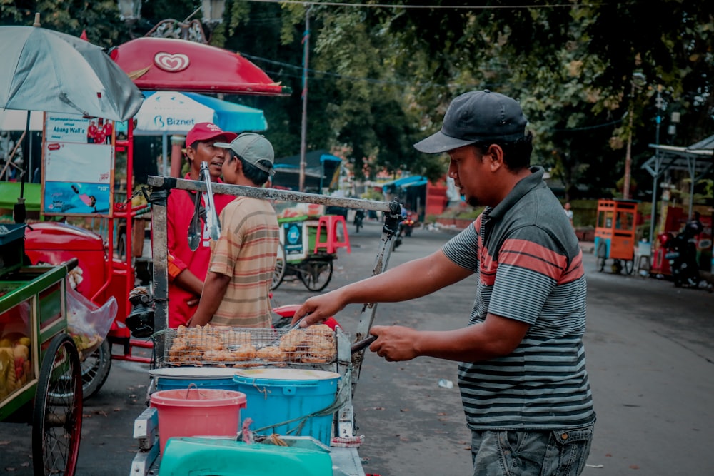 a man is cooking food on a cart