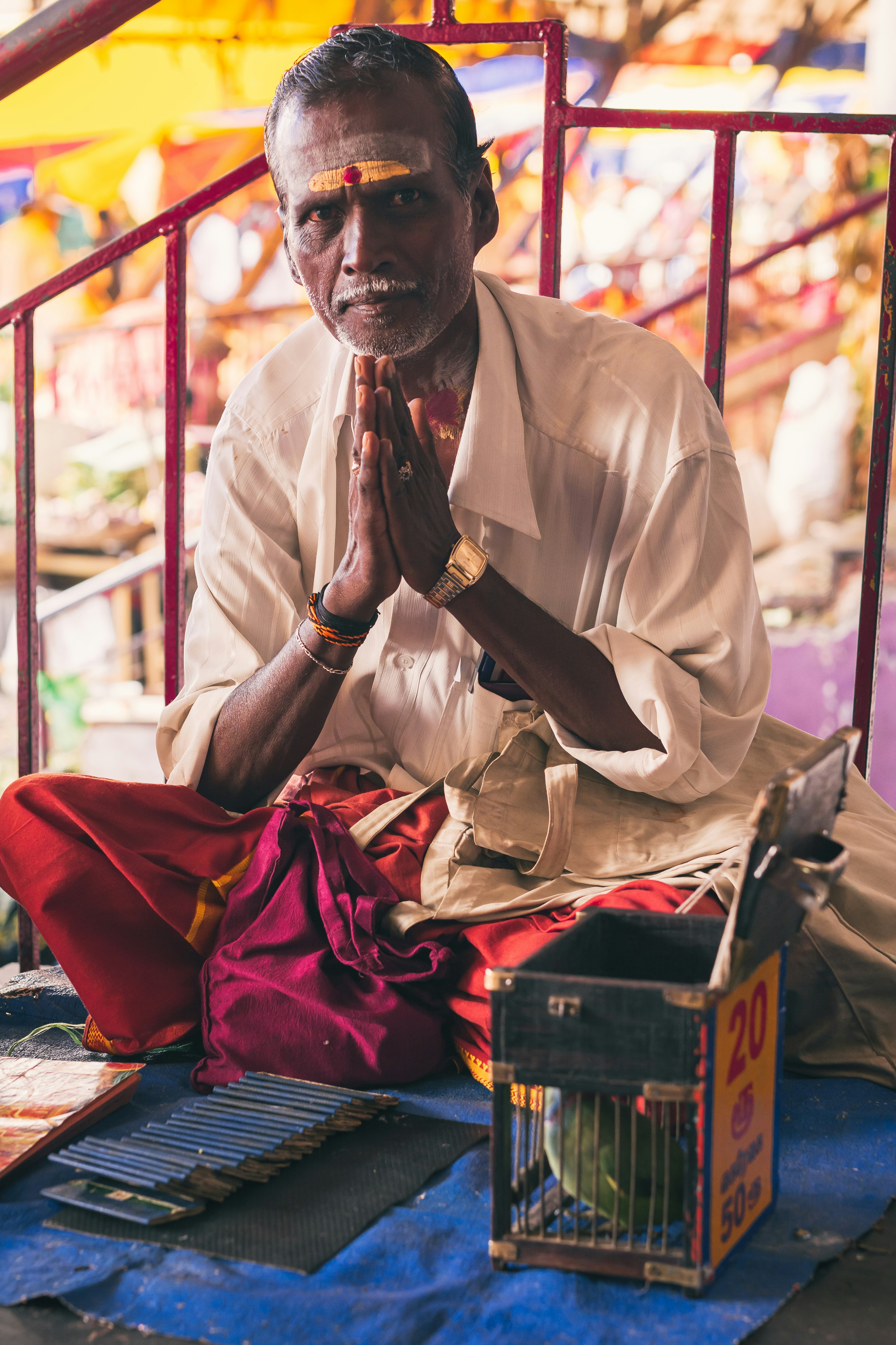 a man sitting on the ground with his hands clasped