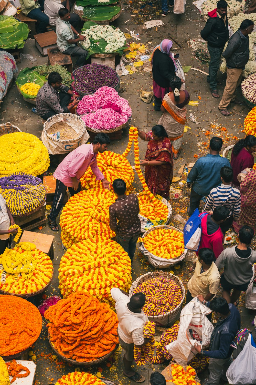 a group of people standing around a bunch of flowers