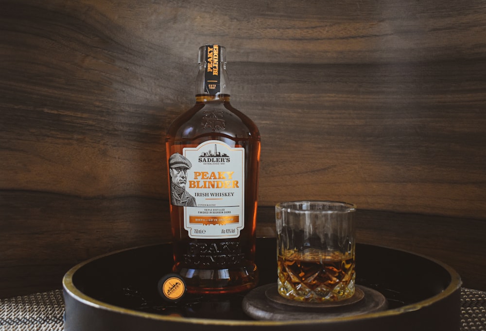 a bottle of whisky next to a glass on a tray