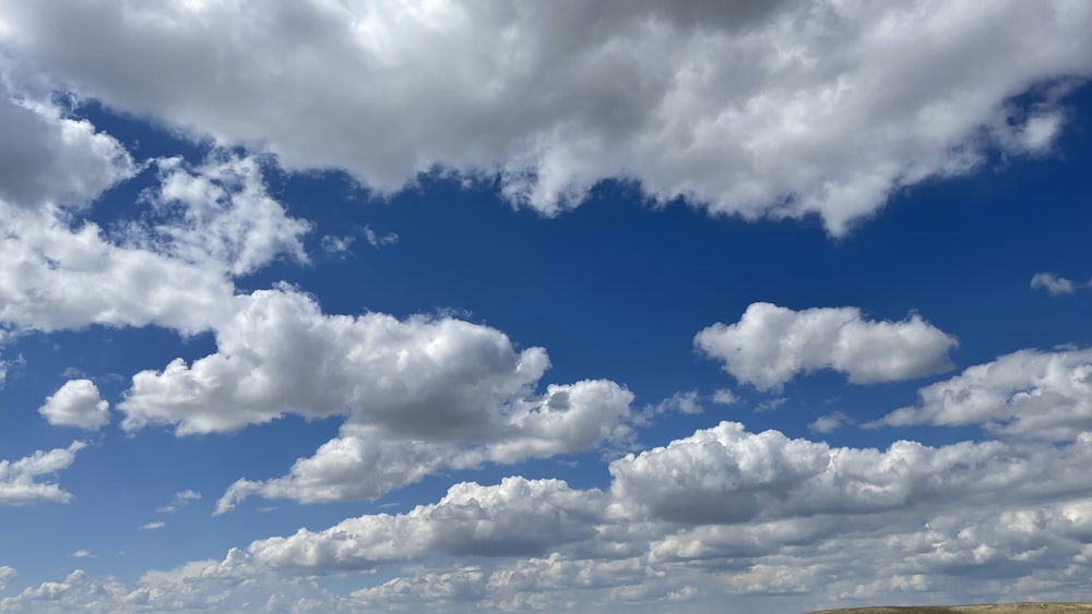 the sky is filled with white clouds and blue sky