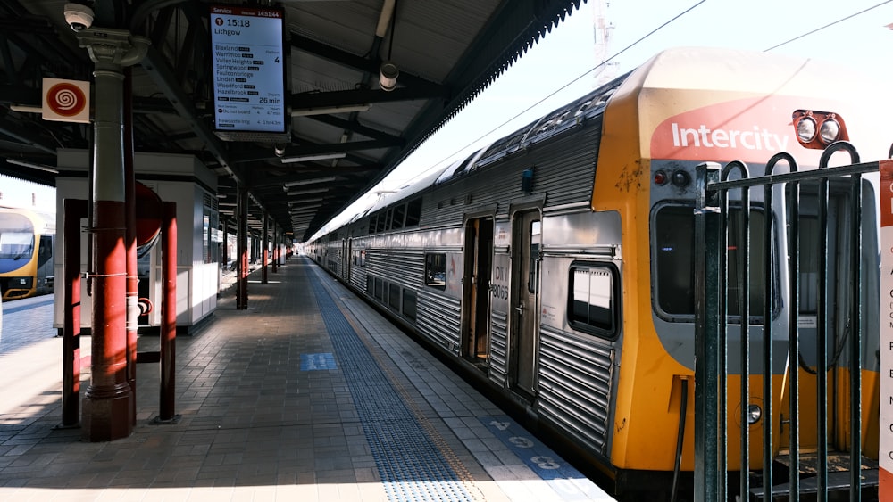 a yellow and silver train at a train station