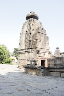 Ancient temple carved in stone, nestled amidst greenery in the district