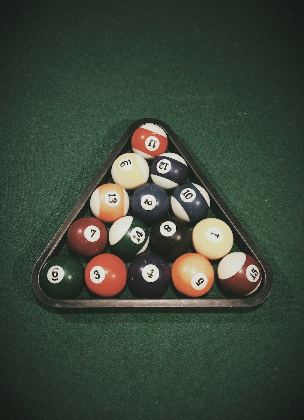 a triangle shaped pool table with pool balls