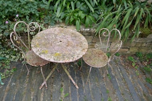 Rattan patio coffee table set on a stone patio surrounded by greenery.