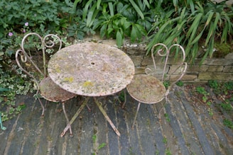 Outdoor marble table with detailed craftsmanship surrounded by garden greenery