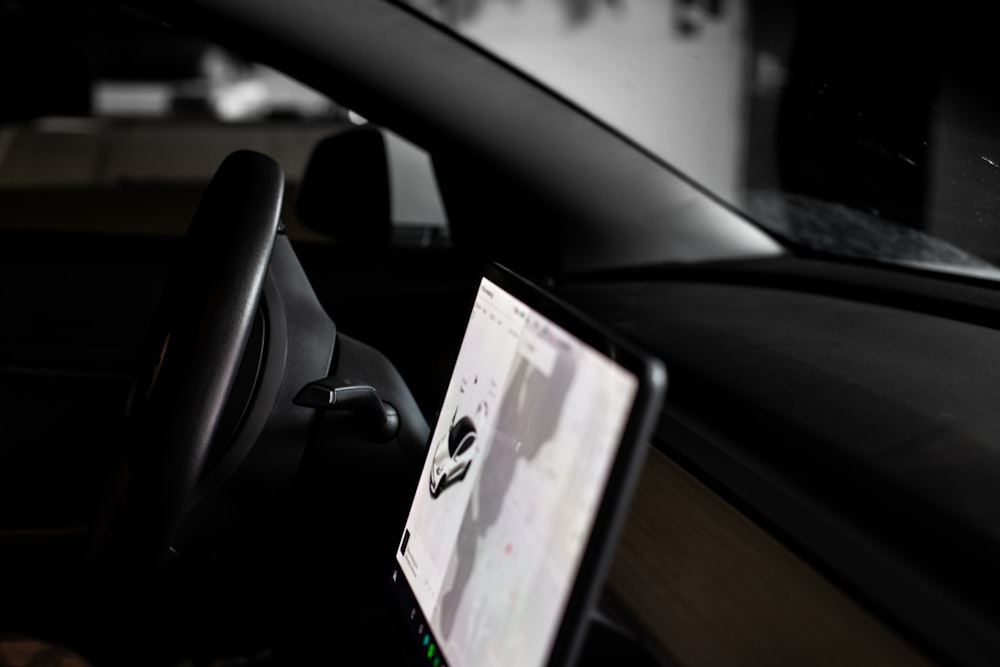 a car dashboard with a monitor and steering wheel