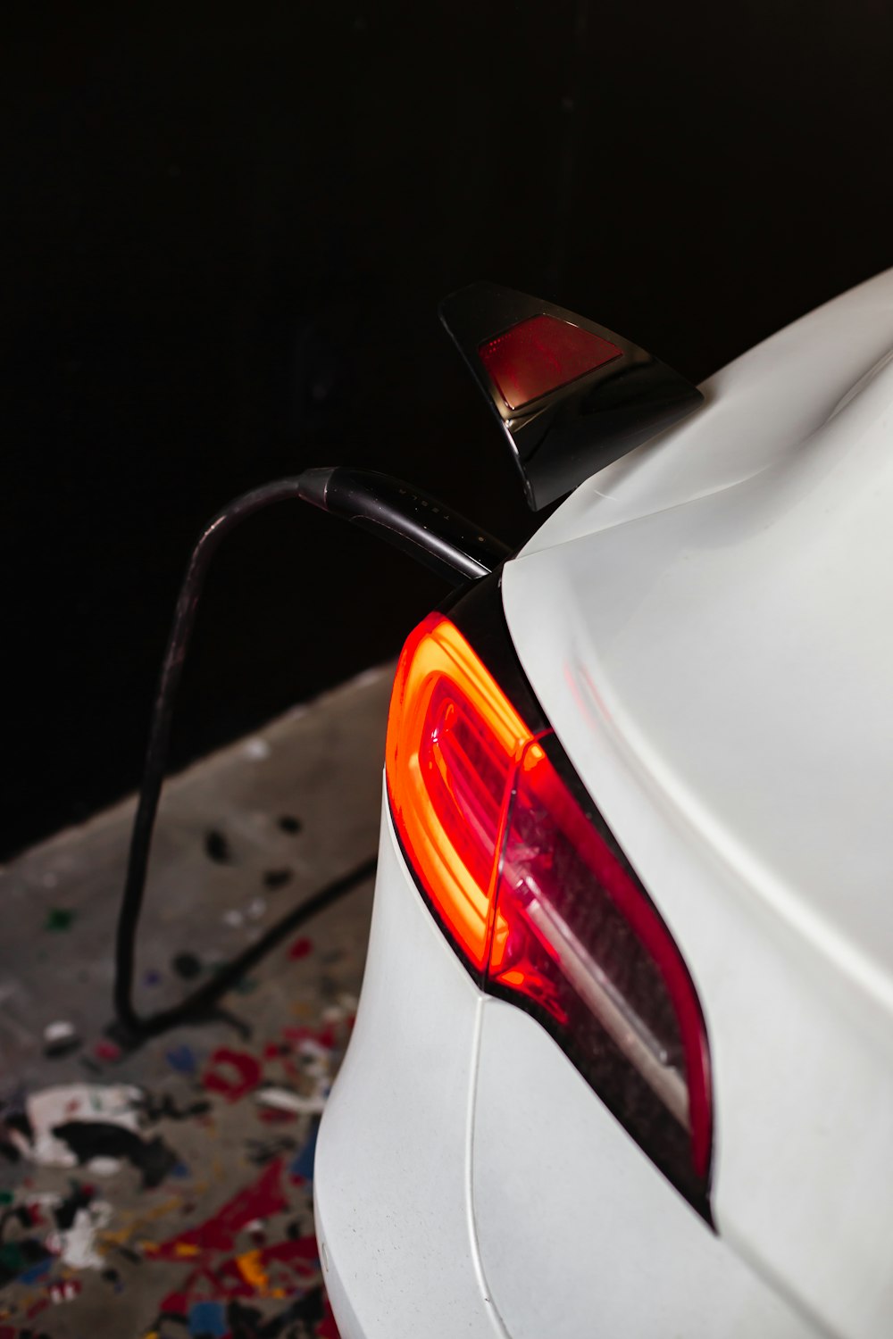 a close up of a white car with a red tail light