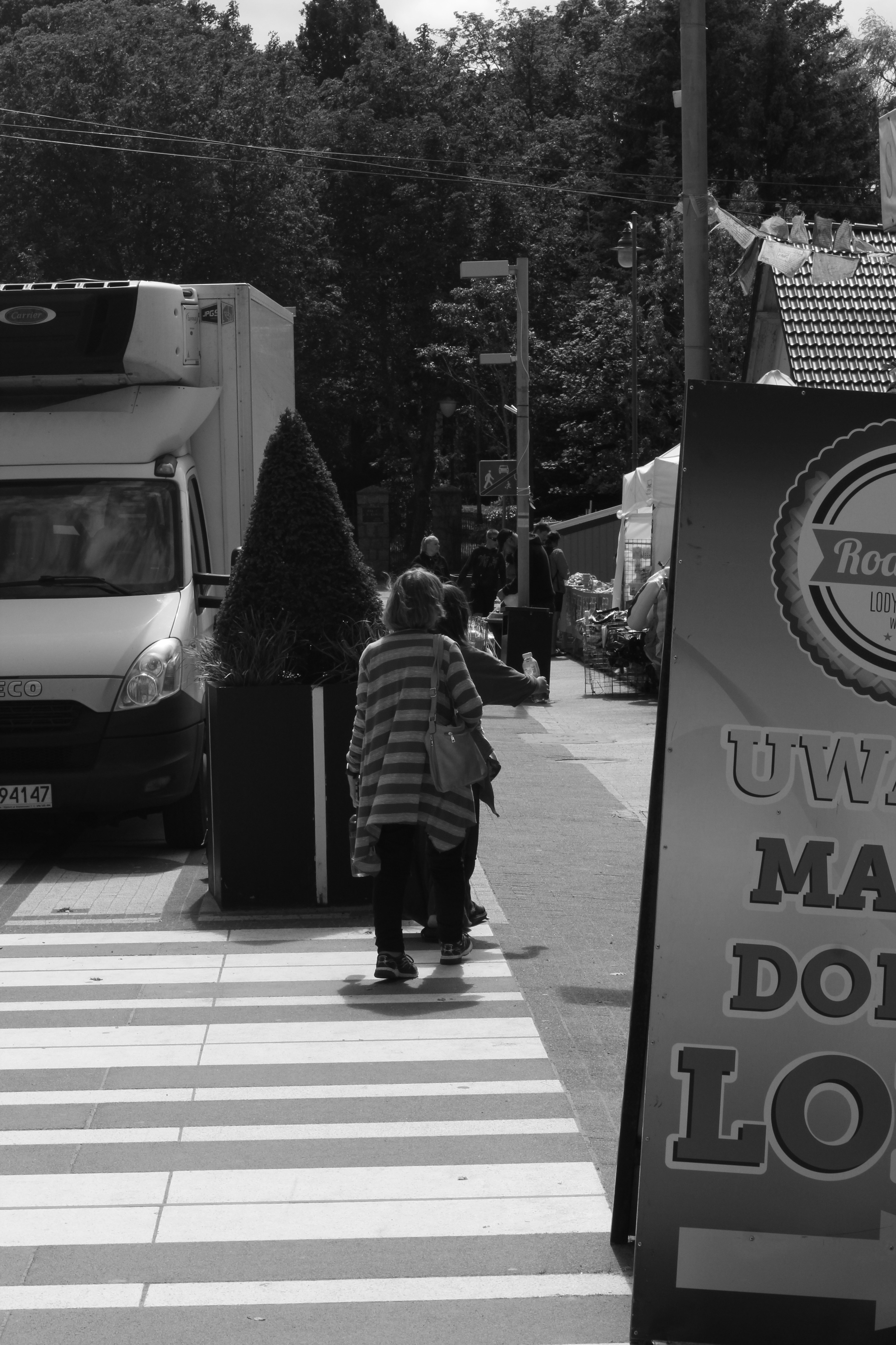 a black and white photo of a woman walking down the street
